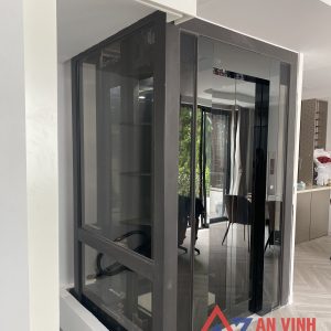 Thang máy gia đình vách kính inox gương đen