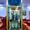 Thang máy vách kính gia đình inox gương vàng xen kính xanh